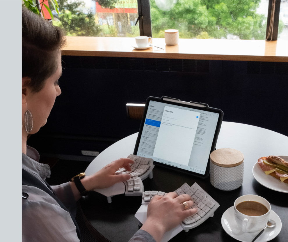Office worker uses Glove80 keyboard wirelessly on tablet
